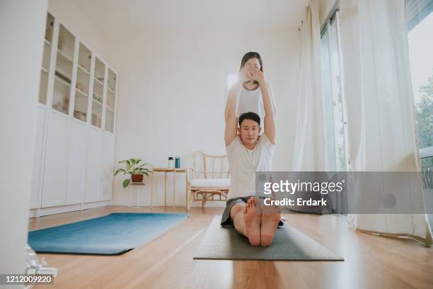 junges paar genießt yoga zu hause - bandscheibenvorfall stock-fotos und bilder