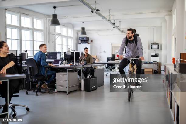 man riding home on a bike from office - work arrival stock pictures, royalty-free photos & images