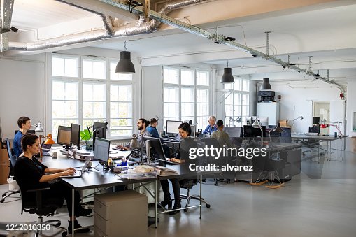 Busy modern open plan office with staff Busy modern open plan office with staff