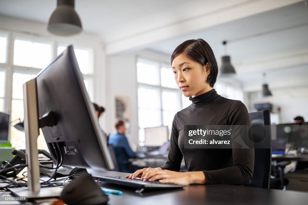 Woman busy working at her desk in open plan office