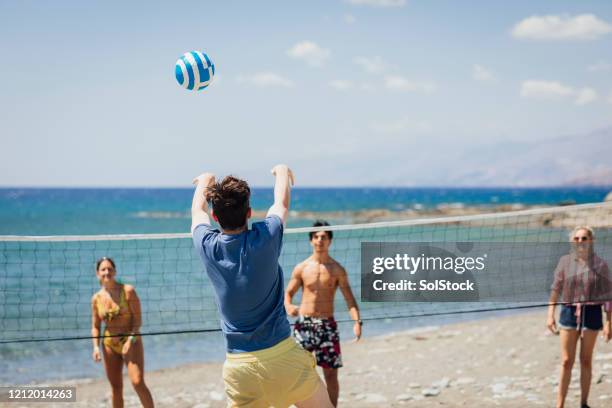 vrienden die strandvolleyball samen spelen - zuid europa stockfoto's en -beelden