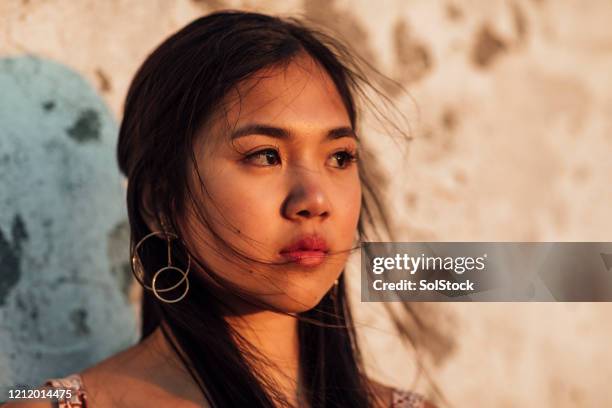 hoofd dat van mooi meisje wordt ontsproten dat vanaf camera bij schemering kijkt - filipino girl stockfoto's en -beelden