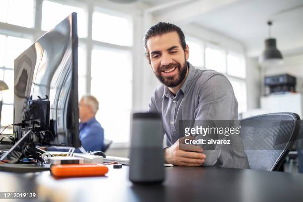 businessman using digital speaker at office - help:category stock pictures, royalty-free photos & images