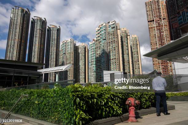 Person stands in front of buildings standing at the Sorrento residential complex, left, the Waterfront residential complex, developed by Wing Tai...