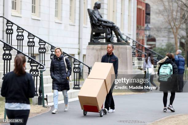 Sophomore Sadia Demby moves her belongings through Harvard Yard on the campus of Harvard University on March 12, 2020 in Cambridge, Massachusetts....