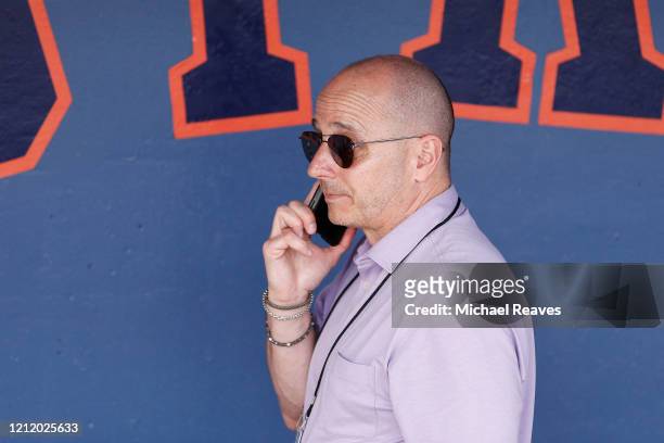 New York Yankees general manager Brian Cashman talks on the phone prior to a Grapefruit League spring training game between the Washington Nationals...