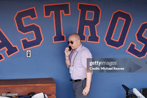 New York Yankees general manager Brian Cashman talks on the phone prior to a Grapefruit League spring training game between the Washington Nationals...