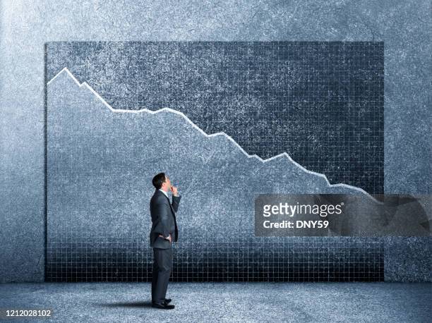 businessman looking up at bear market chart - bear market stock pictures, royalty-free photos & images