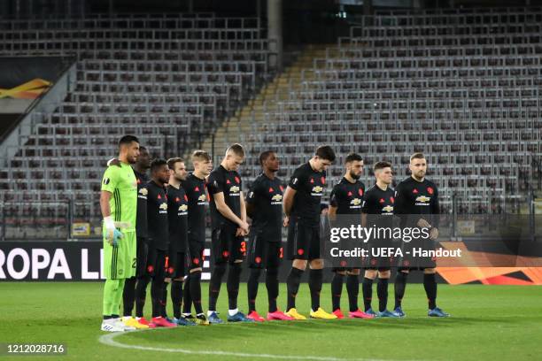 In this handout image provided by UEFA, The Manchester United team take part in a minute of silence prior to the UEFA Europa League round of 16 first...
