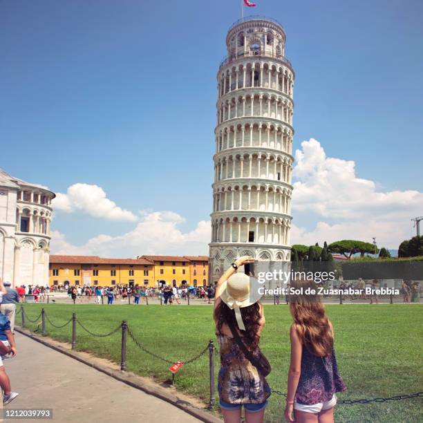 mother and daughter traveling together and taking photos of the leaning tower of pisa - pisa italy stock pictures, royalty-free photos & images