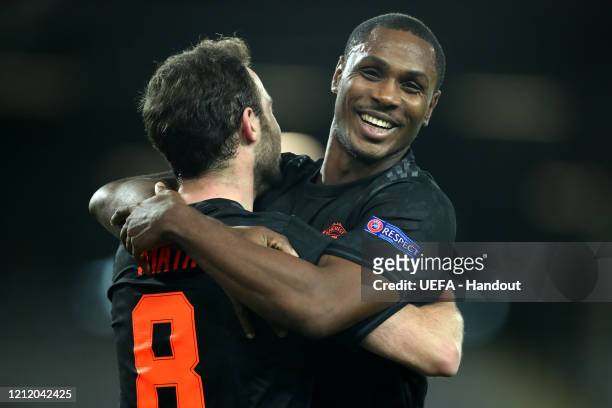 In this handout image provided by UEFA, Juan Mata of Manchester United celebrates with Odion Ighalo after scoring his team's third goal during the...