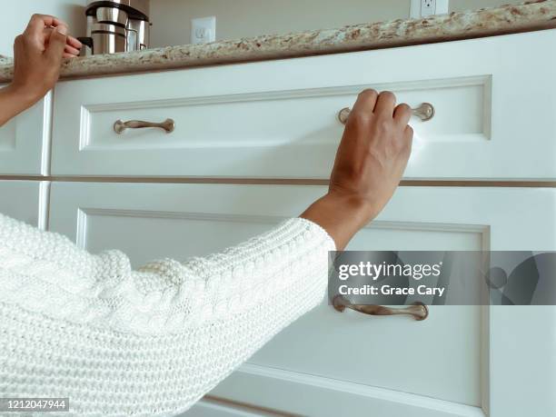 woman cleans cabinet hardware using disinfectant wipe - handle stock-fotos und bilder