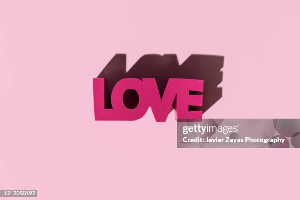 word "love" in 3d block - love is /// stock-fotos und bilder