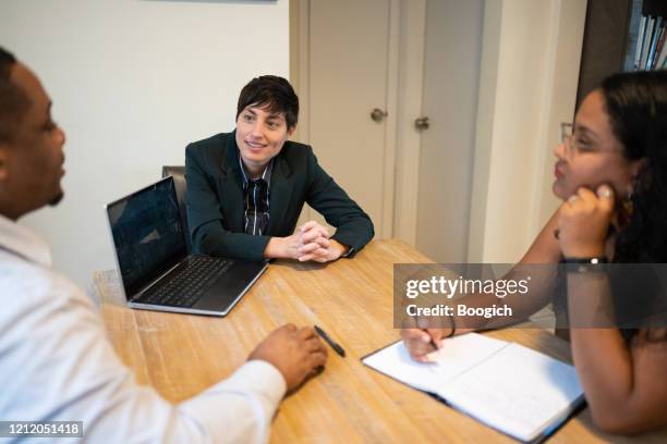 gender neutral person leads community outreach meeting for multi ethnic group of non profit professionals - showus business stock pictures, royalty-free photos & images