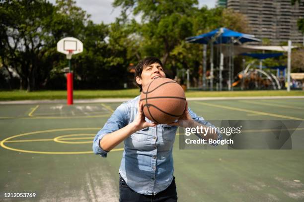 masculine gender non conforming person playing basketball in the park - transgender athlete stock pictures, royalty-free photos & images