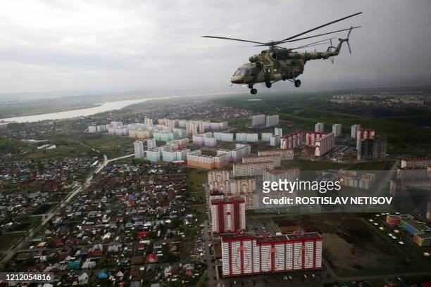 Russian Mi-8 helicopters fly over Novosibirsk during a rehearsal for the Victory Day parade on May 7, 2020. President Vladimir Putin had planned a...