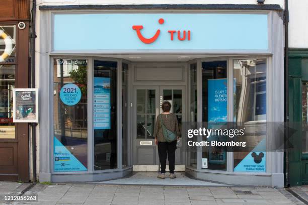 Pedestrian looks in the window of a closed travel agency store, operated by Tui AG, in Canterbury, U.K., on Wednesday, May 6, 2020. Lockdown...