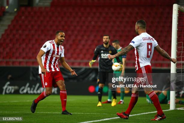 In this handout image provided by UEFA, Youssef El Arabi of Olympiacos FC celebrates with Guilherme after scoring his team's first goal during the...