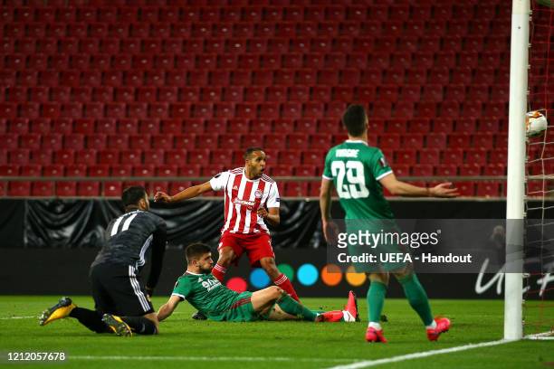 In this handout image provided by UEFA, Youssef El Arabi of Olympiacos FC scores his team's first goal during the UEFA Europa League round of 16...