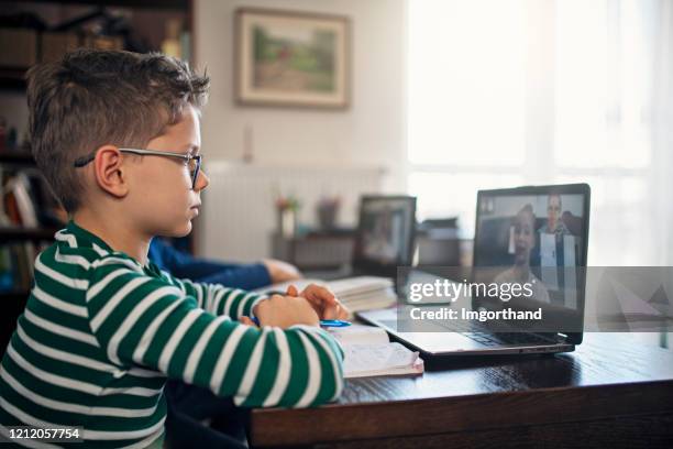 little boys attending to online school class. - distance learning kid stock pictures, royalty-free photos & images