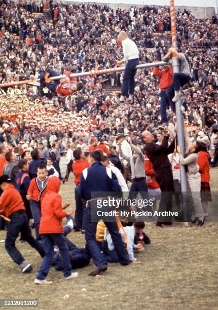 Fans of the Texas Longhorns celebrate and climb on the goal posts after the win against the Texas Christian University Horned Frogs after the rivalry...