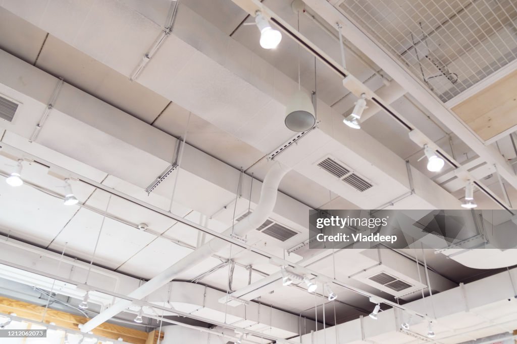 Ventilation ducts system painted in white composition of fire protection under the ceiling