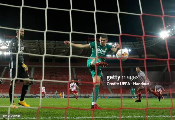 In this handout image provided by UEFA, Youssef El Arabi of Olympiacos FC celebrates after scoring his team's first goal as Conor Coady and Rui...