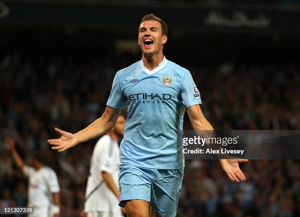 Edin Dzeko of Manchester City celebrates after scoring the opening goal during the Barclays Premier League match between Manchester City and Swansea...