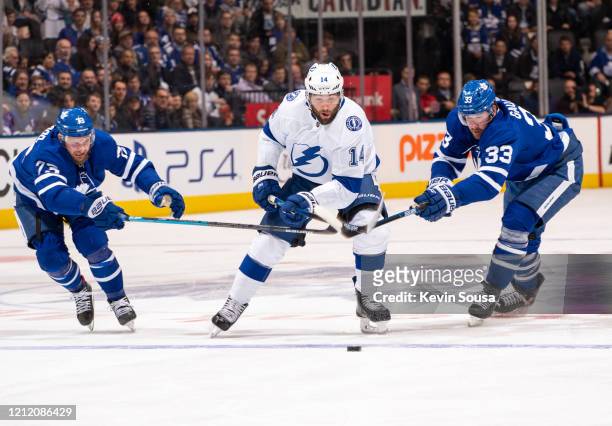 Pat Maroon of the Tampa Bay Lightning battles for the puck against Kyle Clifford of the Toronto Maple Leafs and Frederik Gauthier during the first...