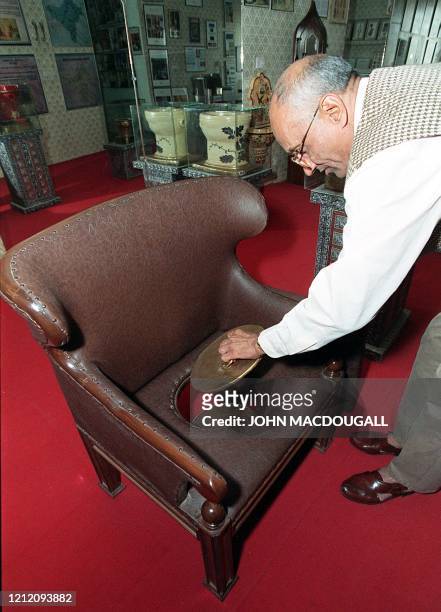 Curator of the Sulabh International Toilet Museum Mulk Raj takes the lid off a concealed hole in this french-made armchair-style toilet in the...