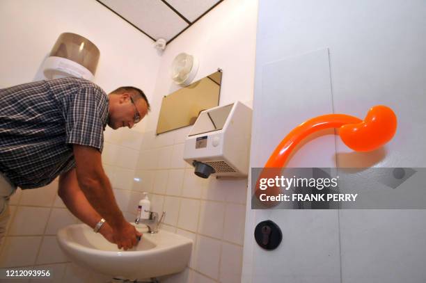 La grippe fait exploser les ventes d'une poignée de porte +anticontamination+" - A man washs his hands in toilets equiped with the first ergonomic...