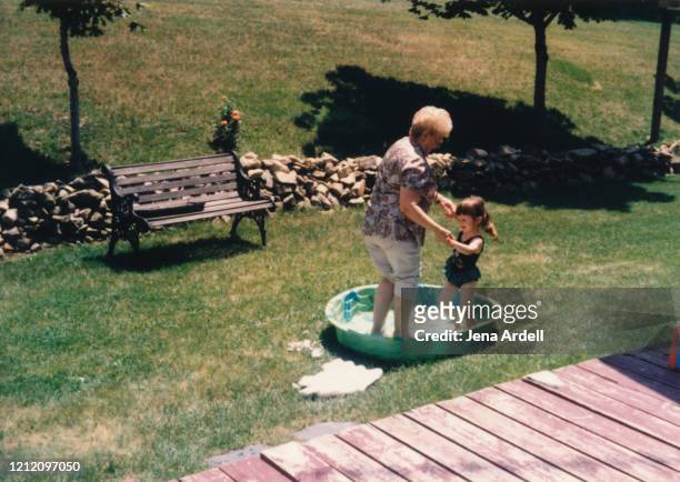 grandmother and granddaughter playing outside, family togetherness - archival stock-fotos und bilder