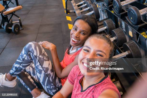 female friends taking a selfie in the gym weight area - gym selfie stock pictures, royalty-free photos & images
