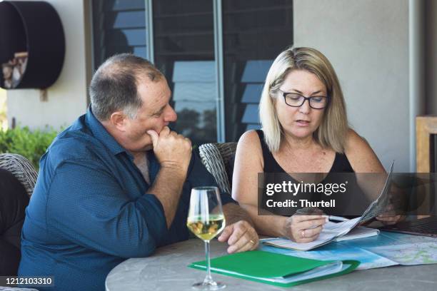 middle aged couple planning holiday - australian economy stock pictures, royalty-free photos & images