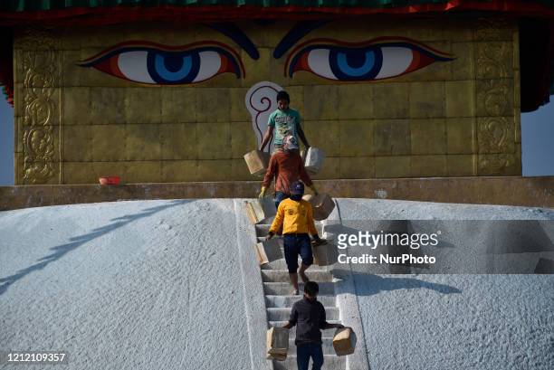 Nepalese Buddhist devotees carrying colors to decorate Boudhanath Stupa, a UNESCO World Heritage Site during celebration the 2,564 Buddha Purnima...