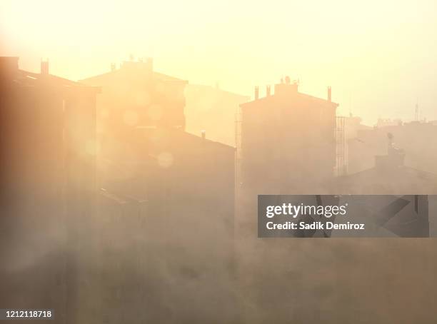smoke covered cityscape over orange color sunset - dramatic weather over istanbul stock pictures, royalty-free photos & images