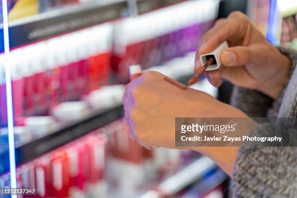 woman trying make-up tone and color - cosmetic sales woman stock-fotos und bilder