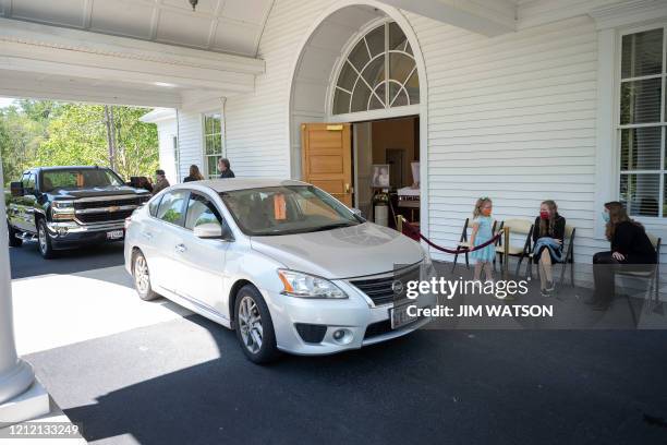 Attendees motor past while speaking with immediate family during a drive-thru viewing for Mrs. Barbara Lipscomb at the Fellows, Helfenbein & Newnam...