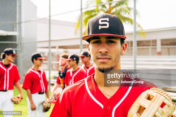 junge hispanische baseballspieler im freien mit handschuh stehen - baseball player headshot stock-fotos und bilder
