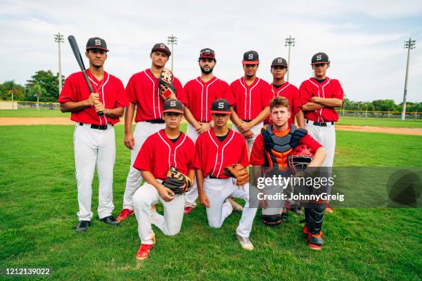 retrato de grupo al aire libre del joven equipo de béisbol hispano - béisbol escolar fotografías e imágenes de stock