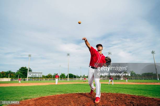 retrato gran angular del lanzador y infield de béisbol hispano - béisbol escolar fotografías e imágenes de stock