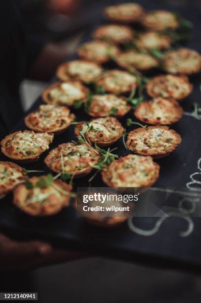 savoury salmon quiche appetisers canapés being presented and served at a party - mini quiche stock pictures, royalty-free photos & images