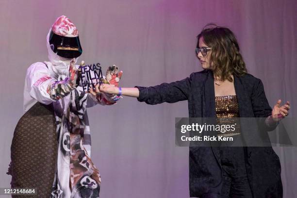 Honoree Erykah Badu accepts an award from host Parker Posey at the Austin Film Society's Texas Film Awards 20th Anniversary at Austin Studios on...