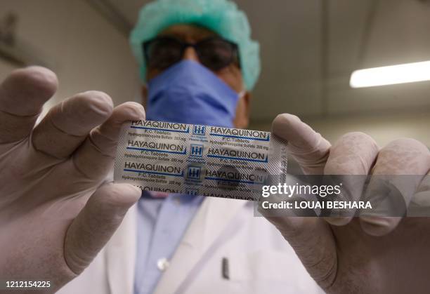 Rashid al-Faisal, the owner of a Syrian pharmaceutical factory, shows a pack of the hydroxychloroquine drug, used in Syria to prevent or cure...