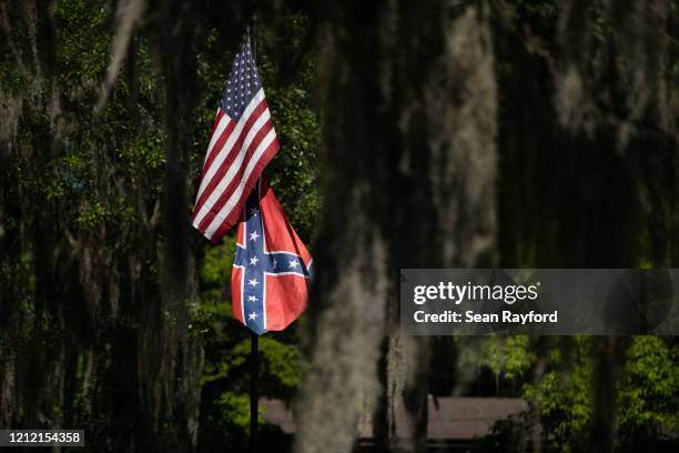 American and Confederate flags fly at a residence in the Fancy Bluff neighborhood on May 7, 2020 where Ahmaud Arbery lived in Brunswick, Georgia....