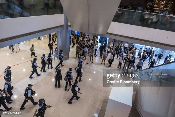 Police officers disperse crowds during a protest inside the International Finance Center Mall in the Central district of Hong Kong, China, on Friday,...