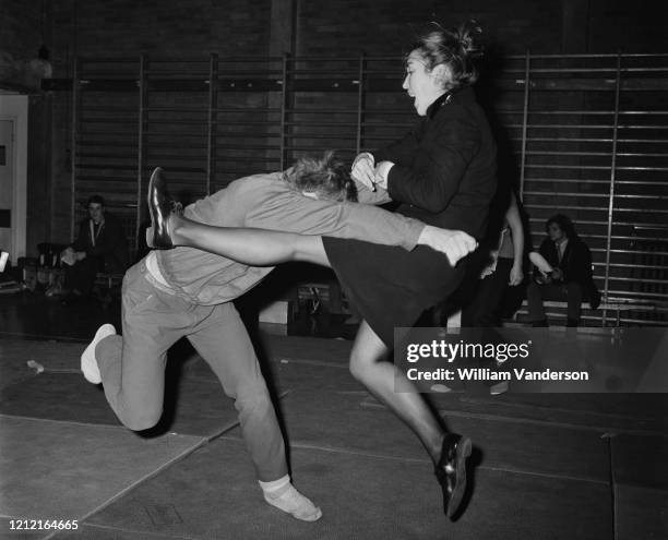 Moya Wood-Heath using a flying kick on an attacker played by PC R Andrews, at the Metropolitan Police women's self defence team display at Norwood...