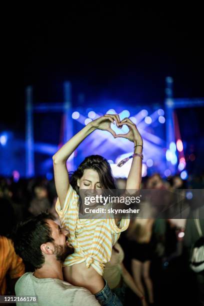 sharing some love on music festival! - couple concert stock pictures, royalty-free photos & images