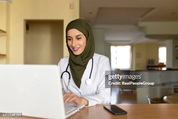 vrouwelijke arts die van huis werkt - headscarf home stockfoto's en -beelden