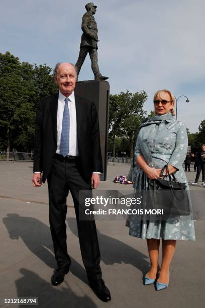 Yves de Gaulle, a grand-son of Charles de Gaulle, and his wife Laurence, pose in front of the statue of General Charles de Gaulle ahead of the start...